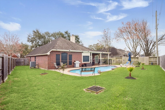 back of house with a fenced in pool, a fenced backyard, brick siding, and central AC