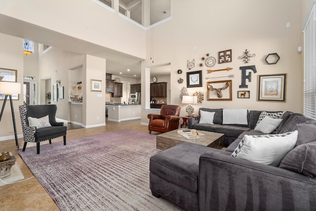 living area with a high ceiling, baseboards, and light tile patterned floors