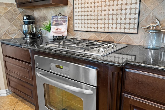 kitchen with dark brown cabinetry, tasteful backsplash, light tile patterned floors, and appliances with stainless steel finishes