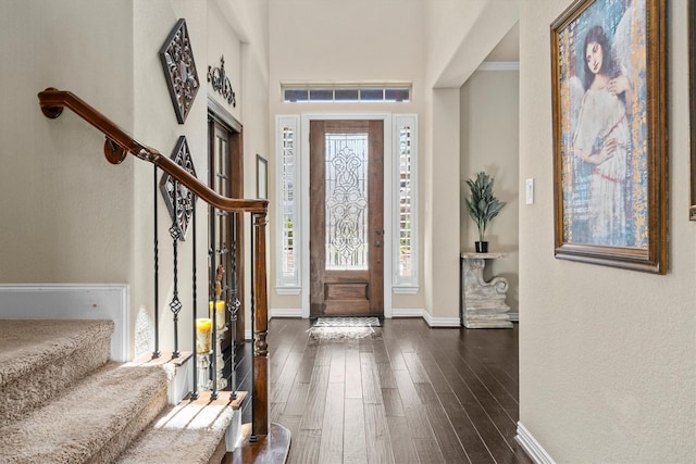 entryway featuring stairs, dark wood-type flooring, visible vents, and baseboards