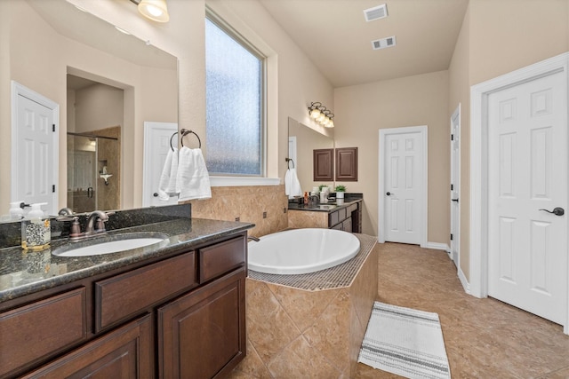 bathroom with a garden tub, a sink, visible vents, and a shower stall