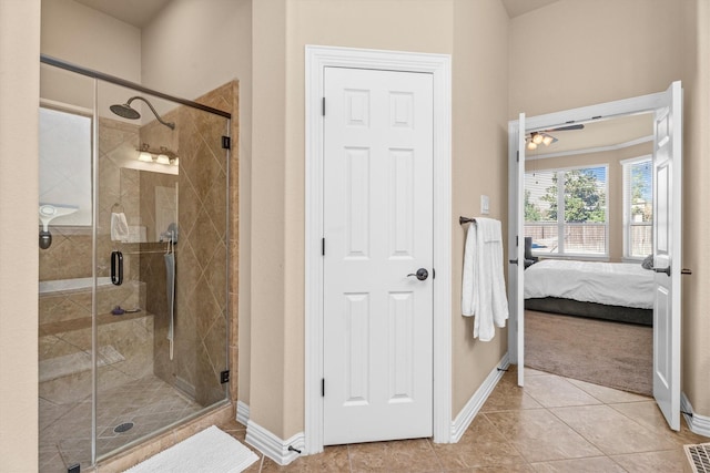 bathroom featuring a shower stall, baseboards, tile patterned flooring, and ensuite bathroom