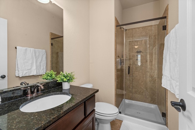 full bath featuring toilet, a shower stall, and vanity