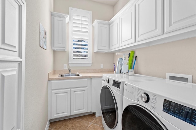 clothes washing area featuring light tile patterned flooring, cabinet space, a sink, and separate washer and dryer