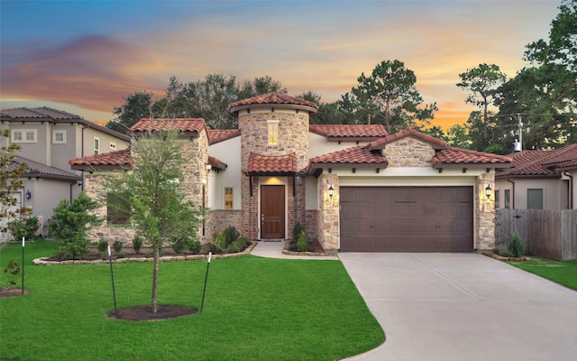 mediterranean / spanish home with a garage, concrete driveway, stone siding, a tile roof, and a front yard