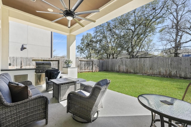 view of patio with grilling area, a fenced backyard, and a ceiling fan