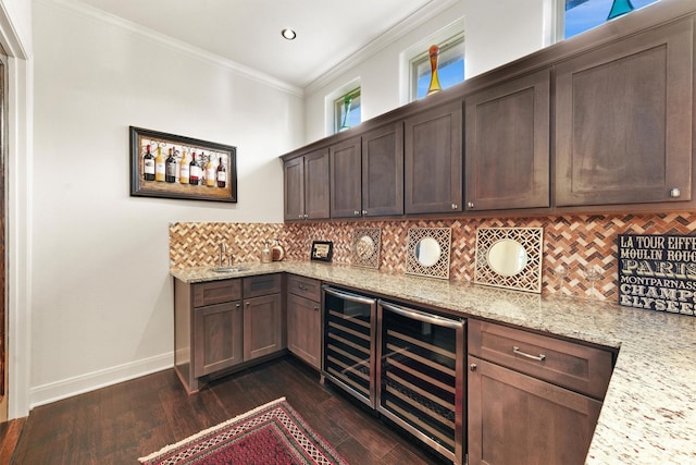 bar with wine cooler, indoor wet bar, backsplash, ornamental molding, and baseboards