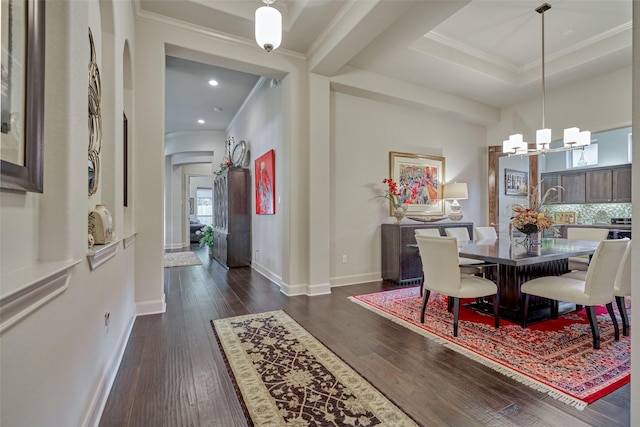 dining area featuring a notable chandelier, crown molding, baseboards, and dark wood-style flooring