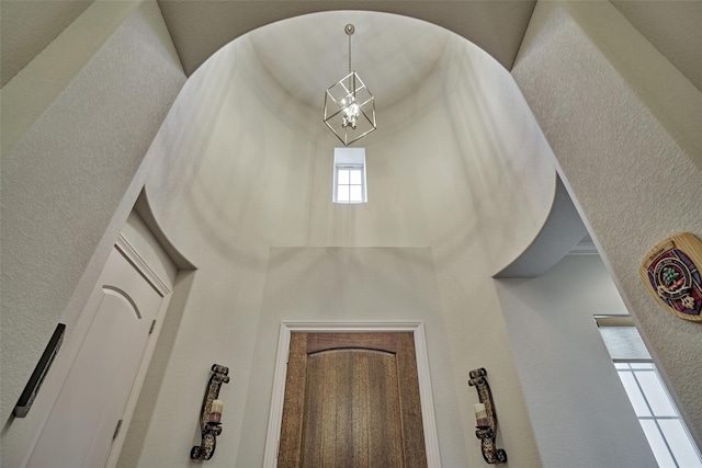 interior details with a chandelier and a textured wall