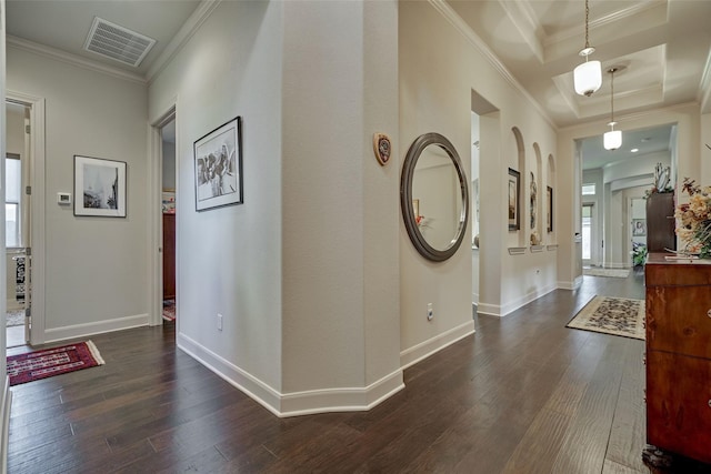 hall with baseboards, visible vents, dark wood-style flooring, and crown molding