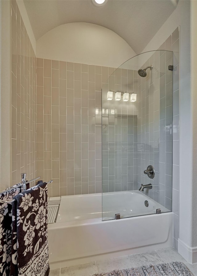 bathroom with lofted ceiling, tile patterned flooring, and tub / shower combination