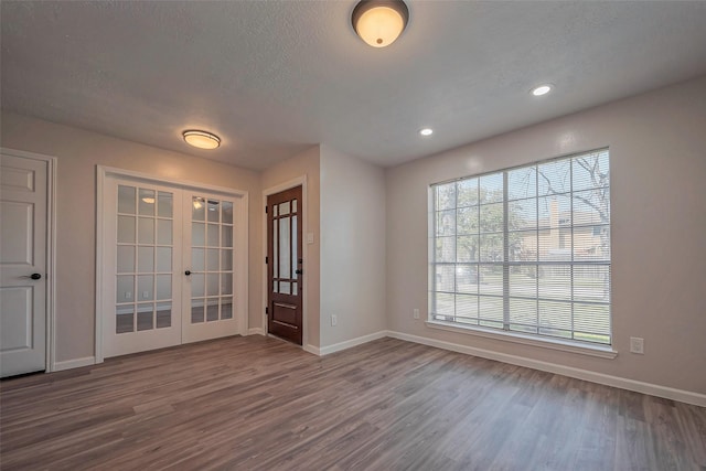 entrance foyer featuring french doors, dark wood finished floors, and baseboards