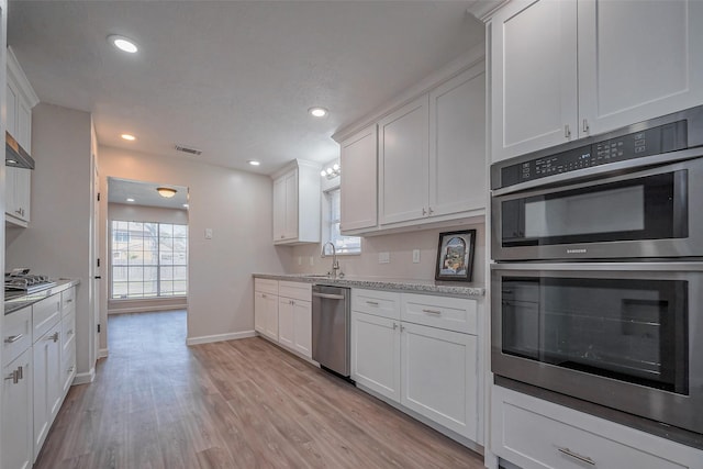 kitchen with light wood-style flooring, recessed lighting, stainless steel appliances, visible vents, and white cabinetry