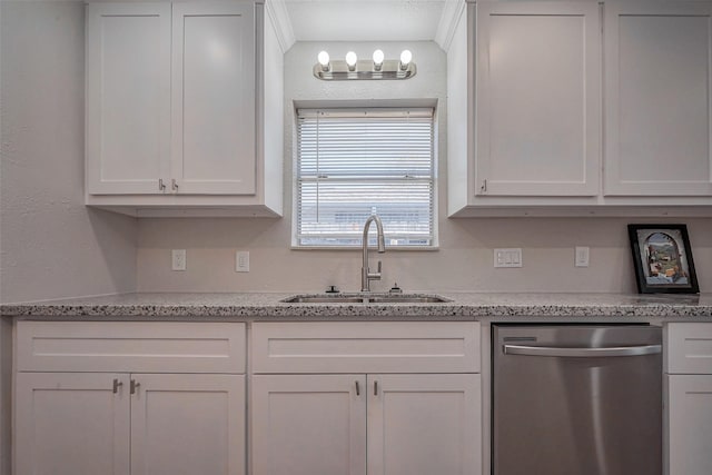 kitchen featuring dishwasher, a sink, white cabinetry, and light stone countertops