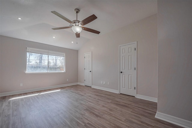 unfurnished room with vaulted ceiling, baseboards, and wood finished floors