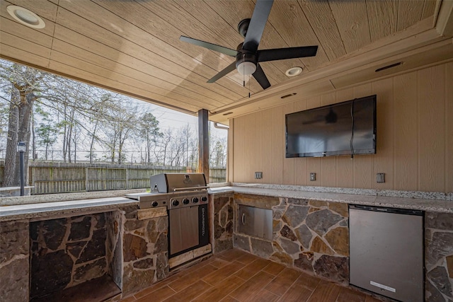 view of patio / terrace with area for grilling, ceiling fan, an outdoor kitchen, and fence