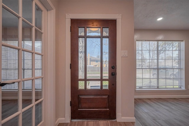 entryway featuring recessed lighting, wood finished floors, and baseboards