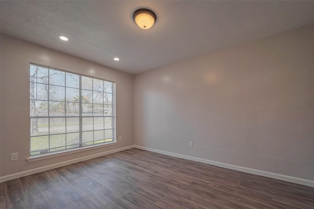 unfurnished room featuring dark wood-style floors, baseboards, a textured ceiling, and recessed lighting