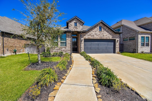 view of front of home featuring a front yard, a garage, brick siding, and driveway