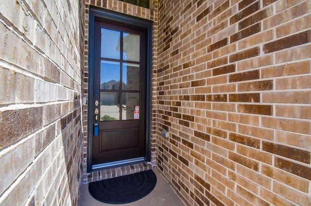 view of exterior entry with brick siding