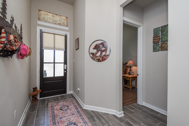 foyer with baseboards and wood finish floors