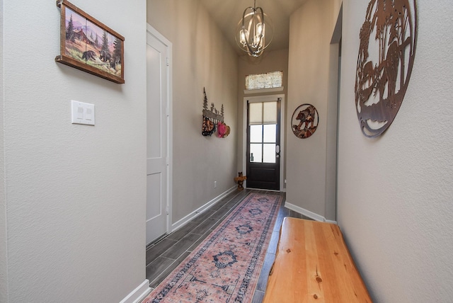 entryway featuring an inviting chandelier, baseboards, and wood finish floors