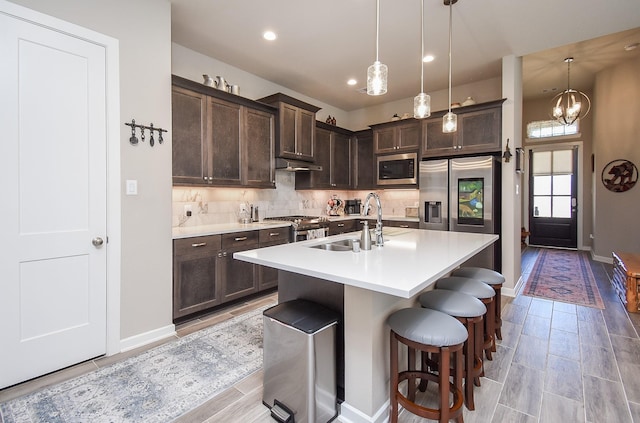 kitchen featuring a sink, tasteful backsplash, appliances with stainless steel finishes, and dark brown cabinets