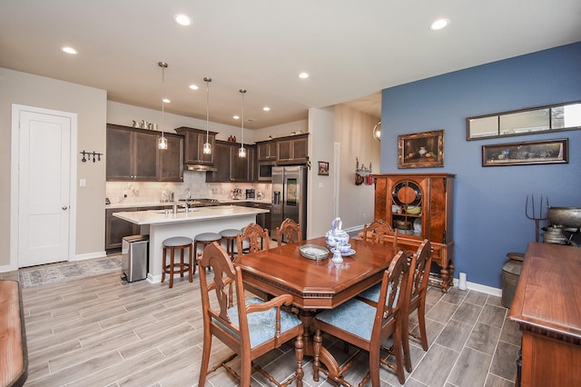 dining area with recessed lighting, baseboards, and wood tiled floor