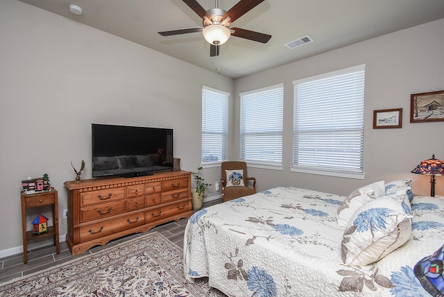 bedroom with visible vents, baseboards, a ceiling fan, and wood tiled floor