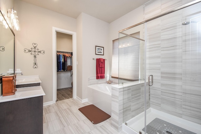 bathroom with a garden tub, a sink, a shower stall, double vanity, and baseboards