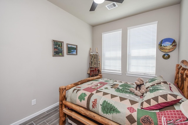 bedroom featuring ceiling fan, wood finished floors, visible vents, and baseboards