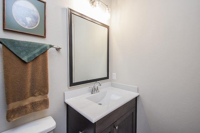 half bathroom featuring toilet and vanity