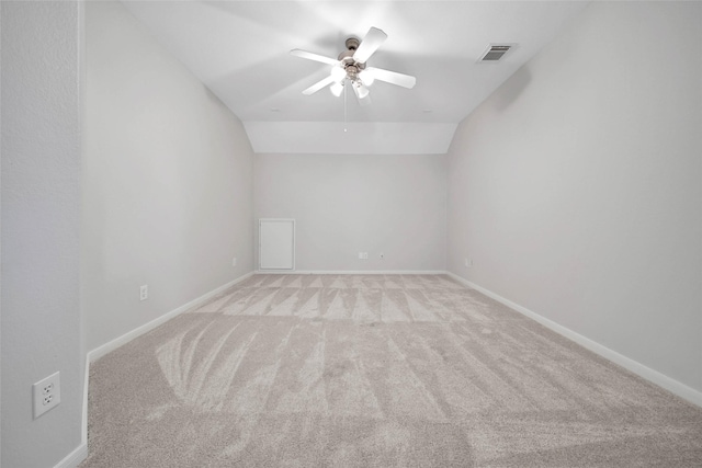 unfurnished room featuring lofted ceiling, visible vents, light carpet, ceiling fan, and baseboards