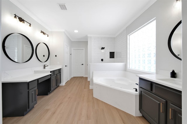 full bathroom with visible vents, ornamental molding, a sink, wood finished floors, and a whirlpool tub