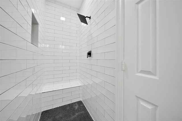 interior details featuring tiled shower