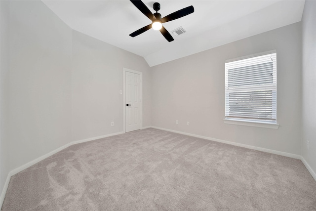 empty room with baseboards, visible vents, a ceiling fan, lofted ceiling, and carpet floors