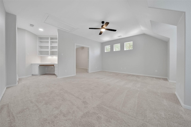 unfurnished bedroom with attic access, baseboards, visible vents, a walk in closet, and built in desk