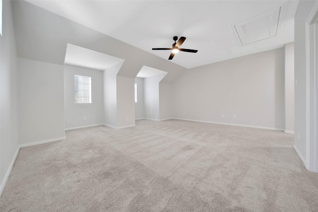 additional living space featuring baseboards, vaulted ceiling, attic access, and light colored carpet