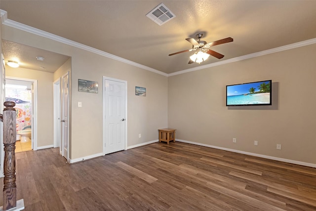 spare room featuring baseboards, visible vents, dark wood finished floors, and ornamental molding