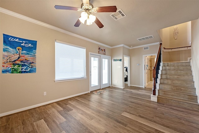 foyer with wood finished floors, visible vents, and stairs