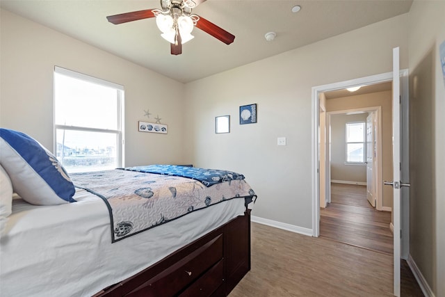 bedroom featuring ceiling fan, light wood-type flooring, and baseboards