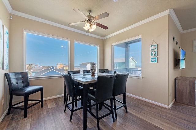 dining space with ceiling fan, ornamental molding, wood finished floors, and baseboards