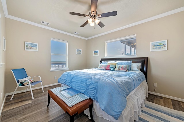 bedroom with baseboards, visible vents, wood finished floors, and ornamental molding