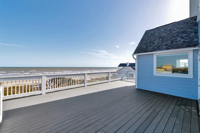 wooden deck with a water view and a view of the beach