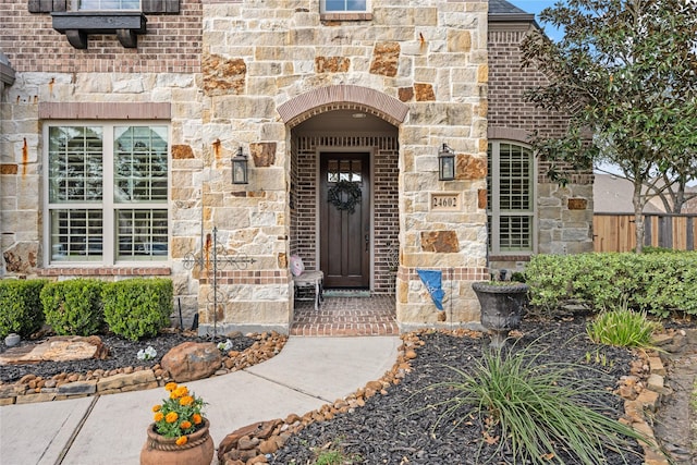 doorway to property with stone siding and brick siding