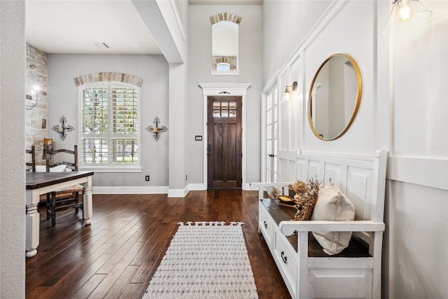 entryway with dark wood-type flooring, visible vents, and baseboards