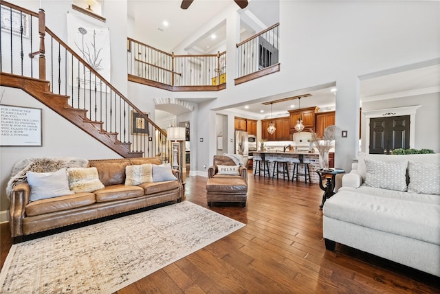 living room with recessed lighting, dark wood-type flooring, a ceiling fan, baseboards, and stairs