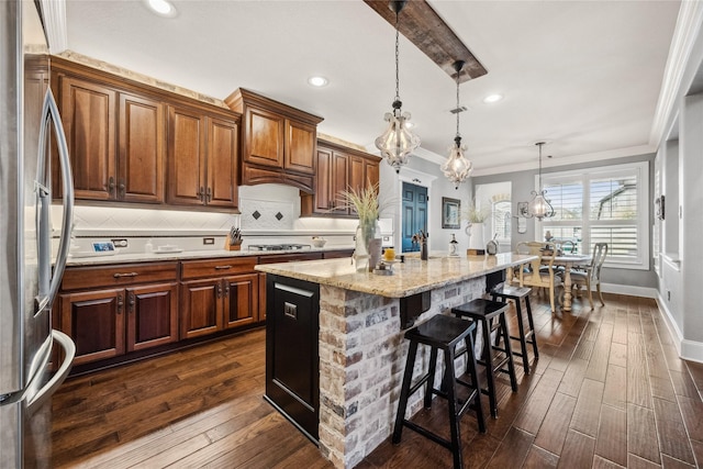 kitchen with stainless steel fridge, an island with sink, dark wood-style floors, a kitchen bar, and backsplash