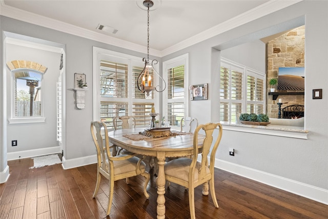 dining area featuring dark wood-style flooring, visible vents, baseboards, ornamental molding, and an inviting chandelier