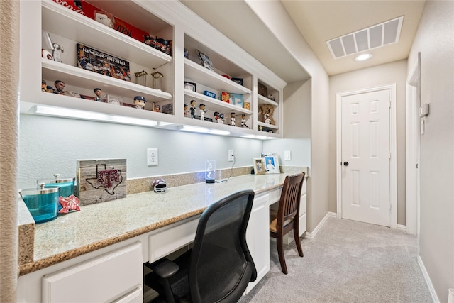 office with baseboards, visible vents, light colored carpet, and built in study area